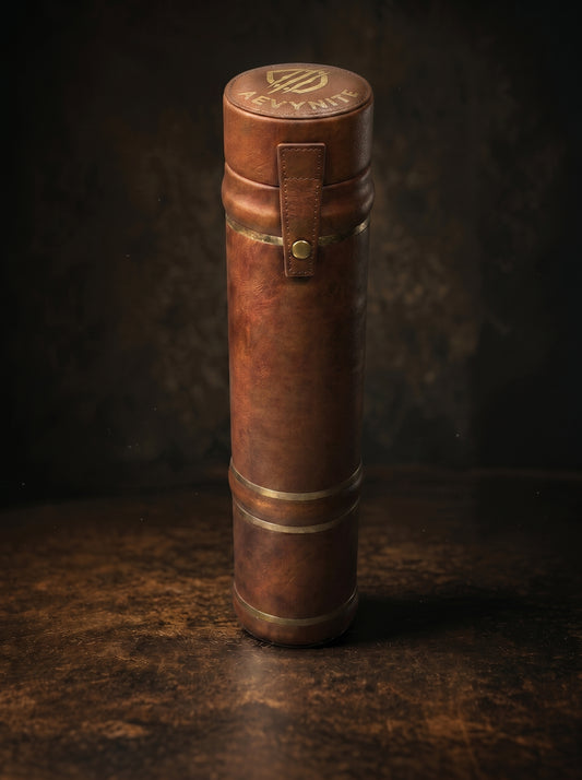 Brown leather cylindrical container with gold accents on a dark background
